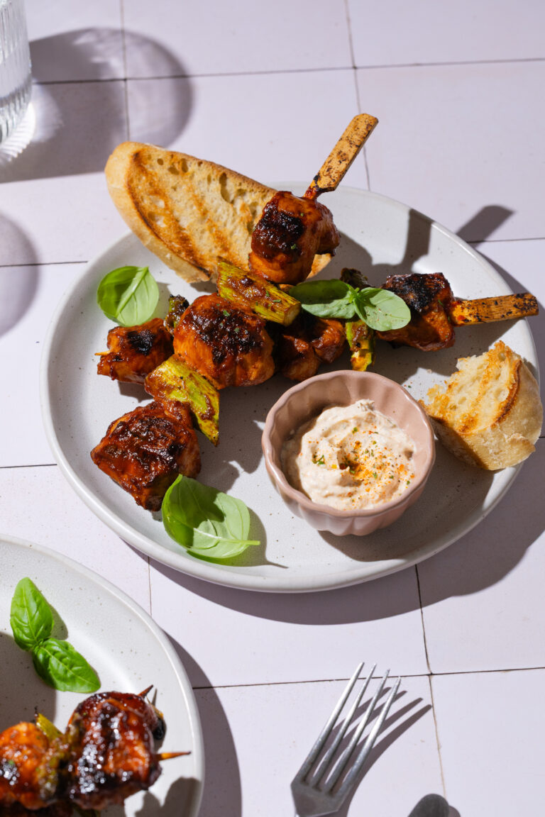 grillspieße auf einem teller mit dip und baguettescheiben